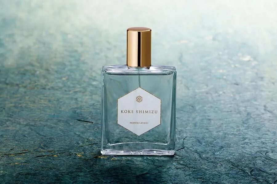 A detailed close-up shot of the KOKE SHIMIZU perfume bottle