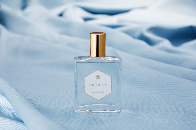 A high-resolution close-up of the SUIREN perfume bottle, highlighting its design and its glass finishing.
