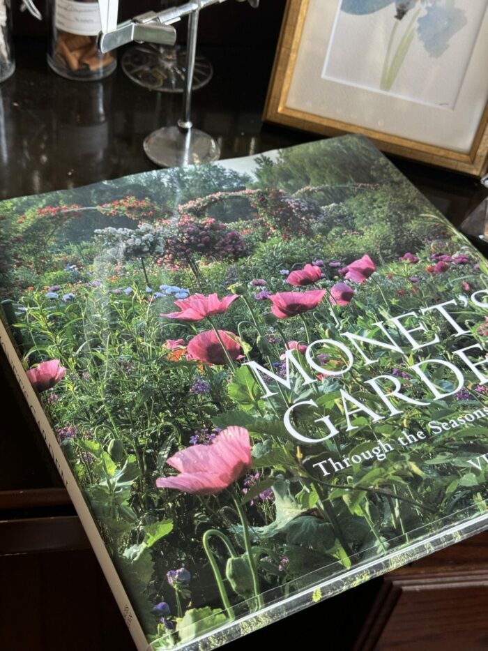 A close-up of the "Monet's Garden" photobook on display inside the perfume boutique, serving as the artistic inspiration for the SUIREN fragrance.